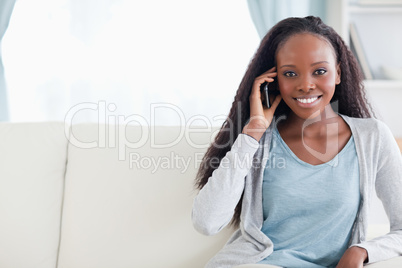 Young woman with cellphone on the sofa