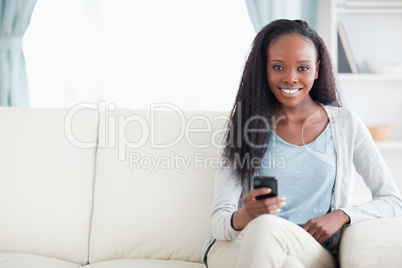 Woman typing text message on the sofa