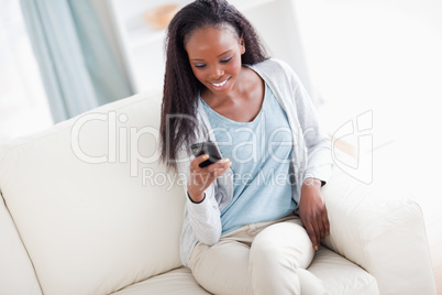 Woman on couch reading text message