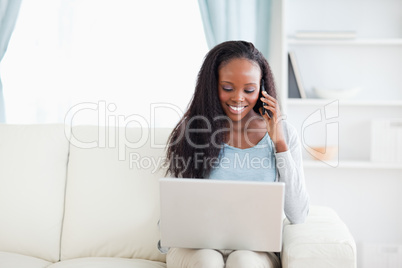 Woman with laptop and smartphone on the sofa