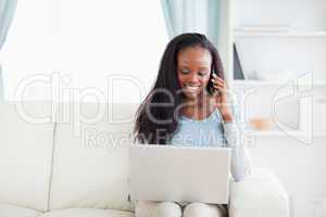 Woman with laptop and smartphone on the sofa