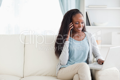 Woman with smartphone and notebook on the sofa