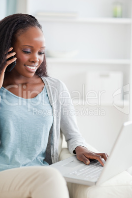 Close up of woman with laptop and smartphone on the sofa