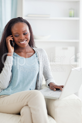 Woman with notebook and cellphone on sofa