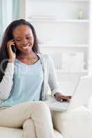 Woman with notebook and cellphone on sofa