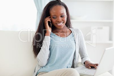 Woman on sofa with laptop and smartphone