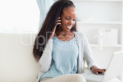 Woman on sofa with smartphone and laptop