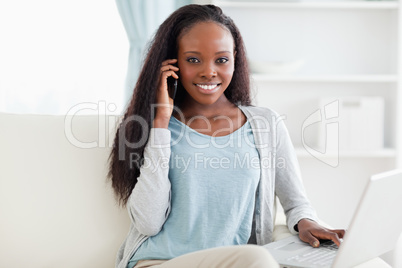 Woman on sofa with notebook and smartphone