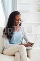 Close up of woman on sofa working on laptop