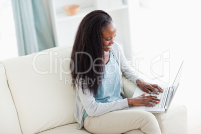 Woman on sofa working on notebook