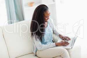 Woman on sofa working on notebook