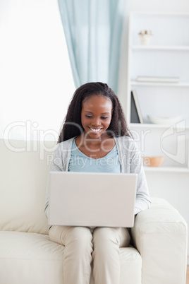 Woman on sofa working on her laptop