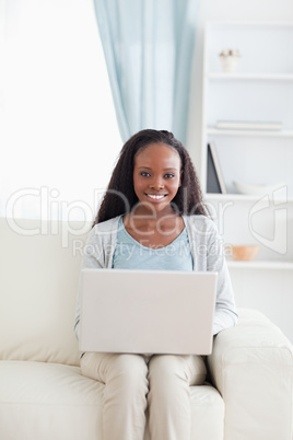 Woman on sofa working on her notebook