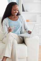 Woman sitting on sofa shopping online