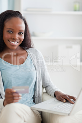 Close up of woman sitting on sofa shopping online