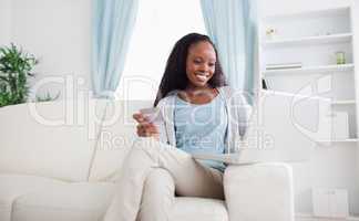 Woman shopping online while sitting on sofa
