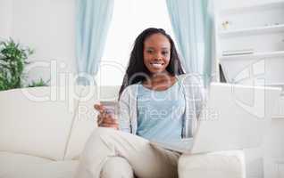 Woman shopping online while sitting on chouch