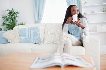 Woman drinking coffee on the sofa