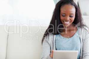 Close up of woman using her tablet on sofa