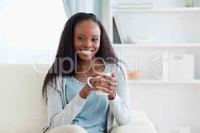 Woman with cup on sofa
