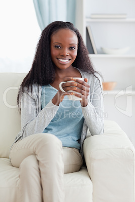 Woman with cup on her sofa