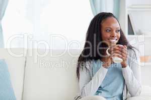 Woman with a cup on couch