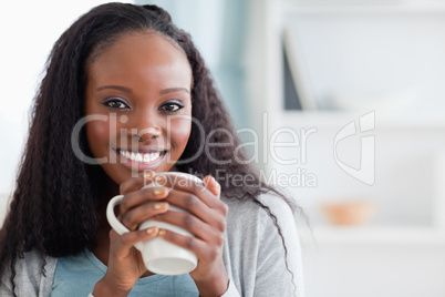 Close up of woman sitting on sofa with a cup