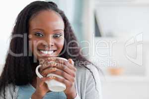 Close up of woman sitting on sofa with a cup