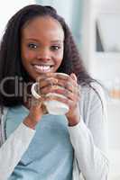 Close up of woman sitting on couch with a cup