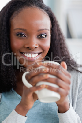 Close up of woman having coffee on couch