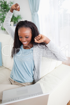 Happy woman with laptop on sofa