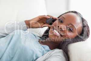 Close up of woman lying on sofa with phone