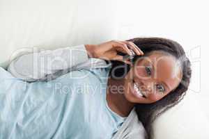 Woman lying on sofa with cellphone