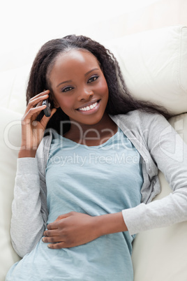 Close up of woman lying on couch with phone