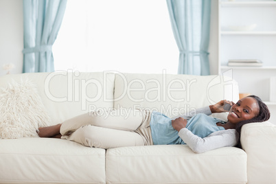 Woman lying on couch with cellphone