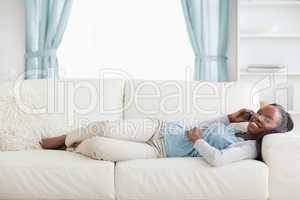 Woman lying on couch with cellphone