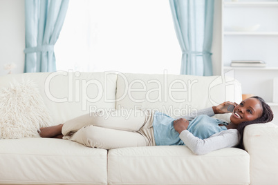 Woman lying on sofa with mobile phone