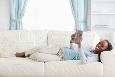 Woman lying on couch reading