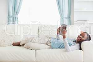 Woman lying on couch reading