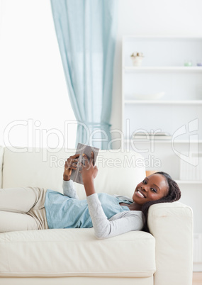 Woman lying on sofa reading a book