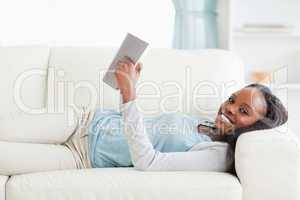 Woman lying on couch reading a novel