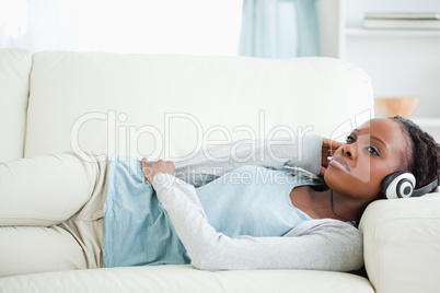 Woman lying on couch listening to music