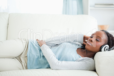 Woman listening to music while lying on couch