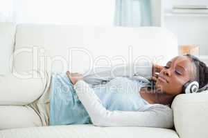 Woman listening to music while lying on couch
