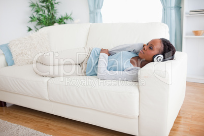 Woman on sofa listening to music