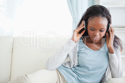 Woman sitting on couch listening to music