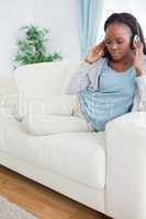 Woman relaxing on sofa with music