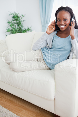 Woman relaxing on couch with music