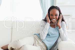 Woman relaxing on sofa with headphones on