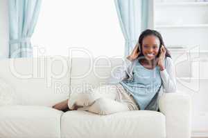 Woman relaxing in living room with music